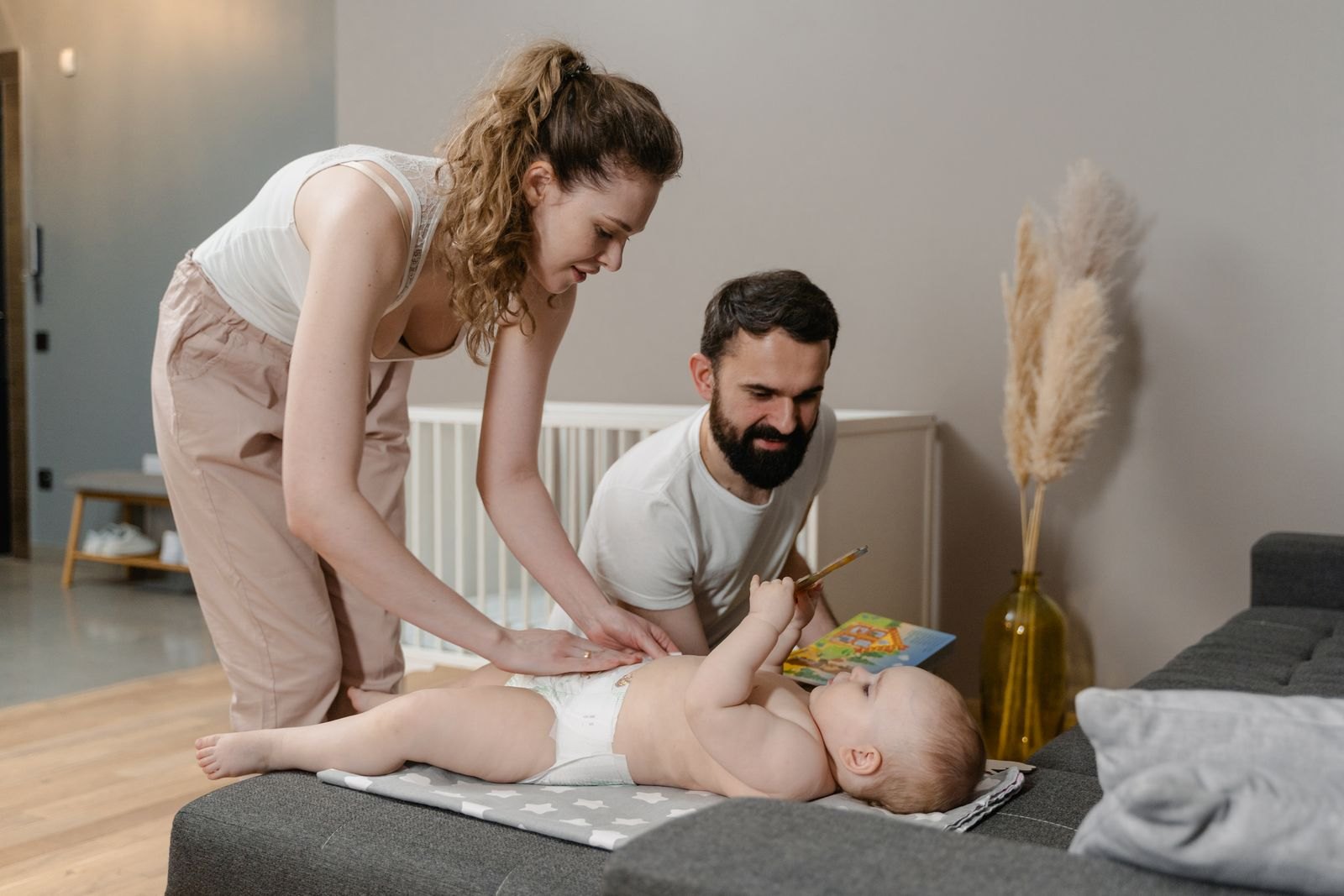 Two parents changing their baby's diaper together