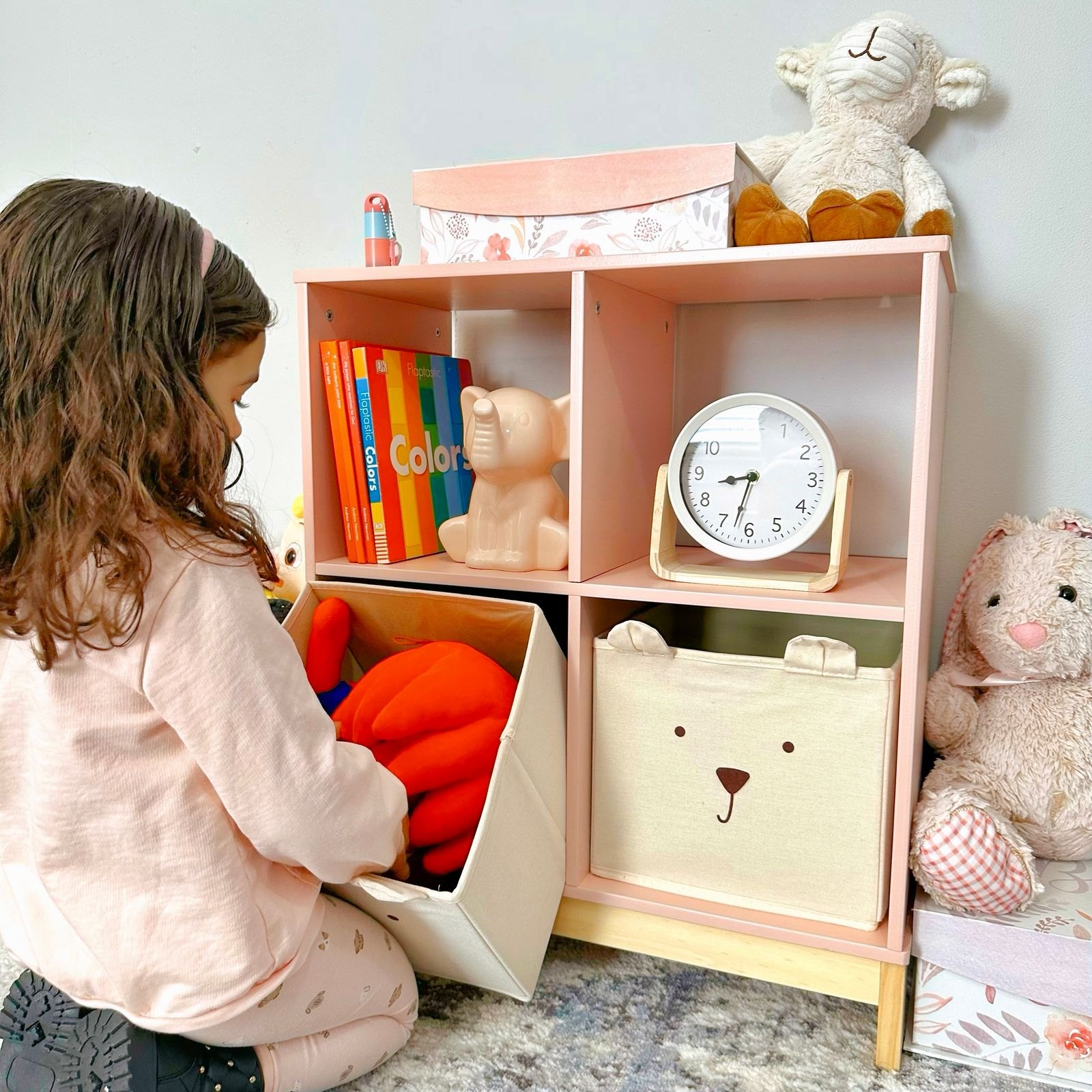 Child organizing toys in colorful nursery shelf