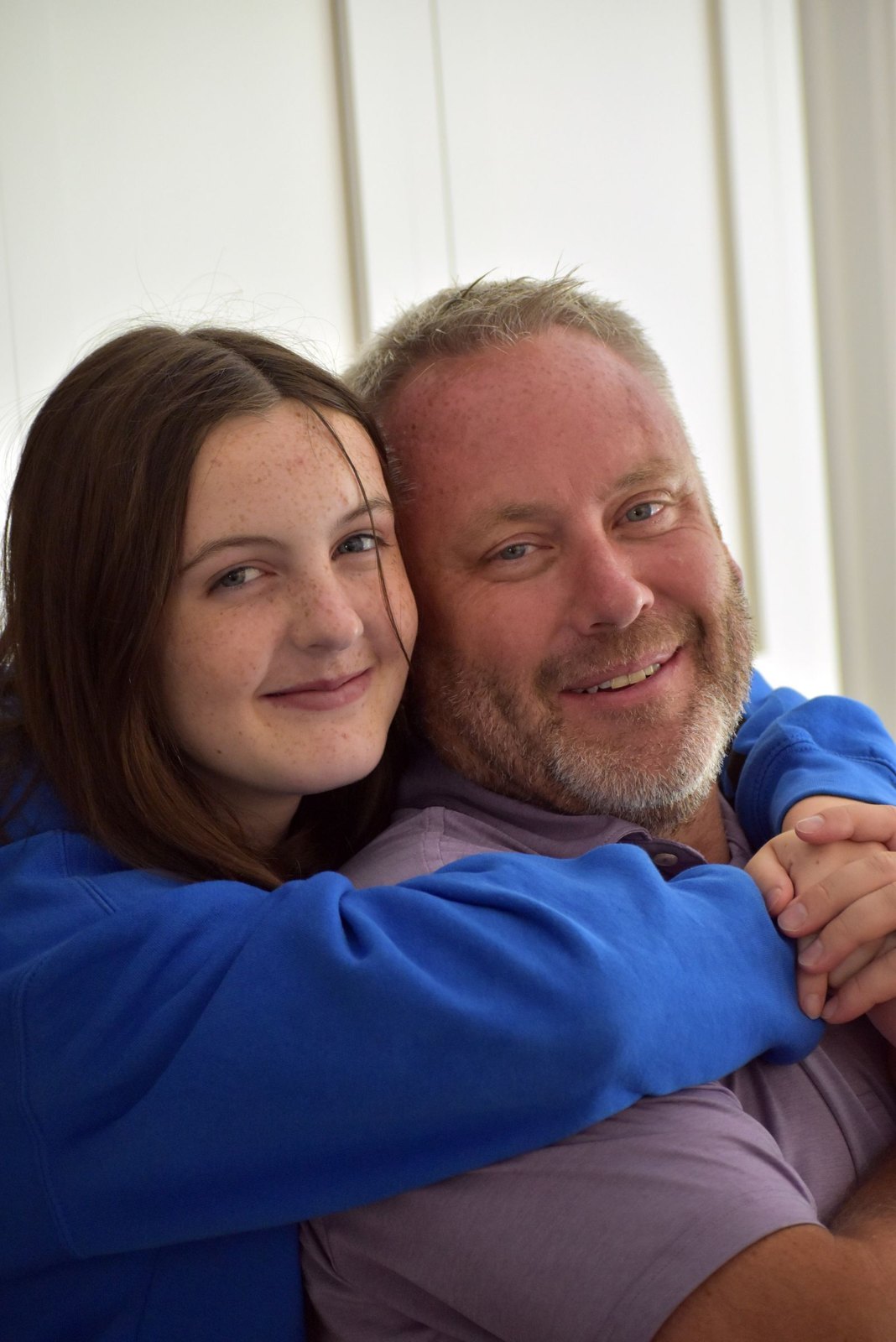 Father and daughter embracing indoors