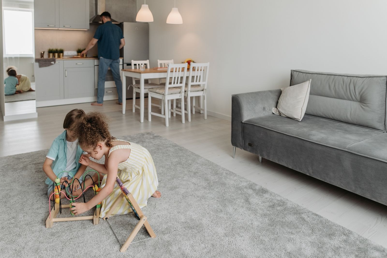 Man doing house chores while his children are playing