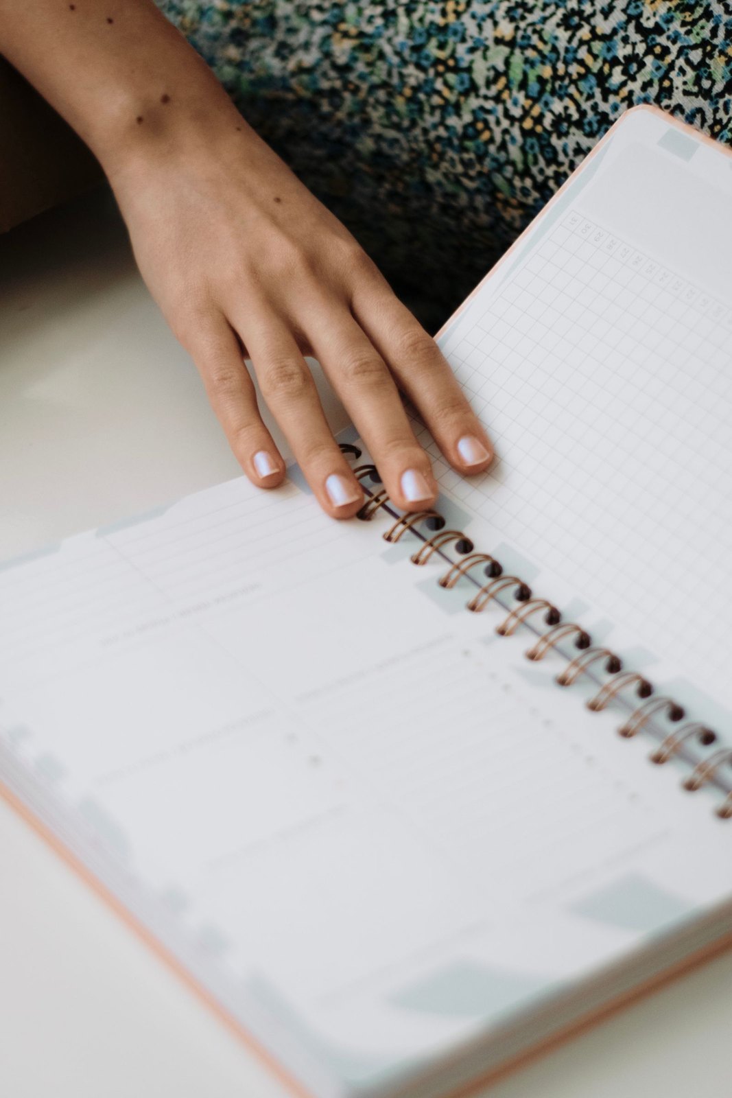 Hand resting on an open notebook