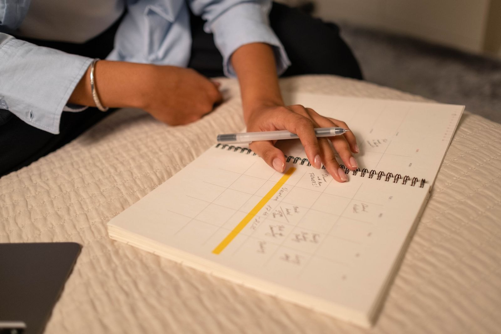 Close up shot of a person writing on a notebook