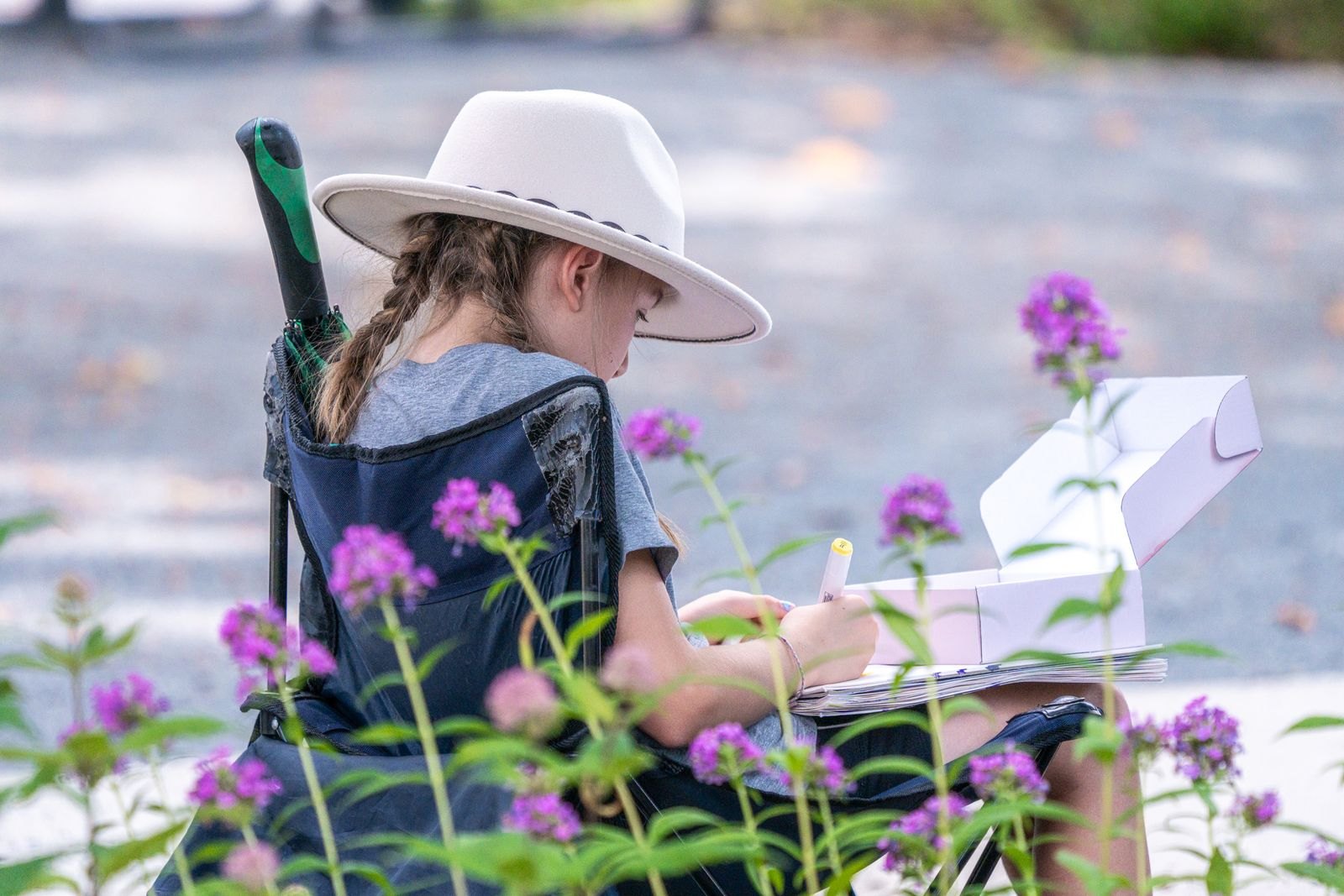 Child sketching outdoors among spring flowers