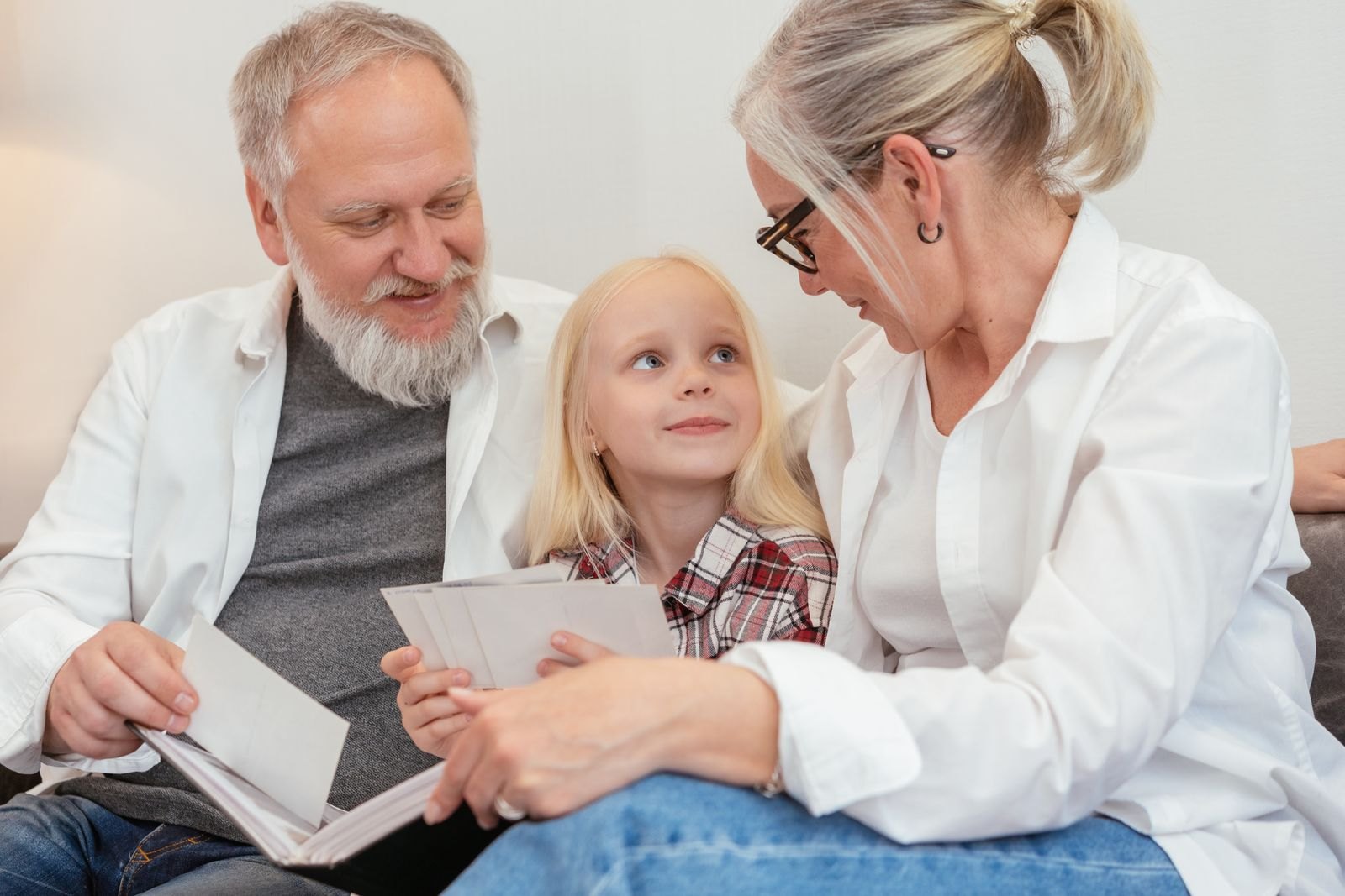 Child looking at a book with grandparents