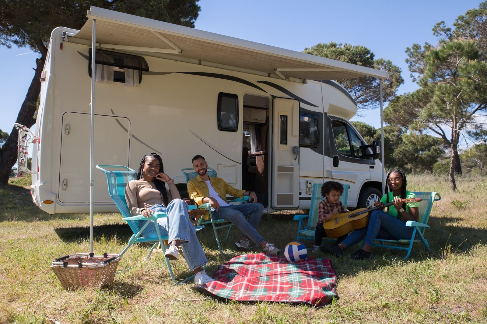 Family relaxing outside a camper van